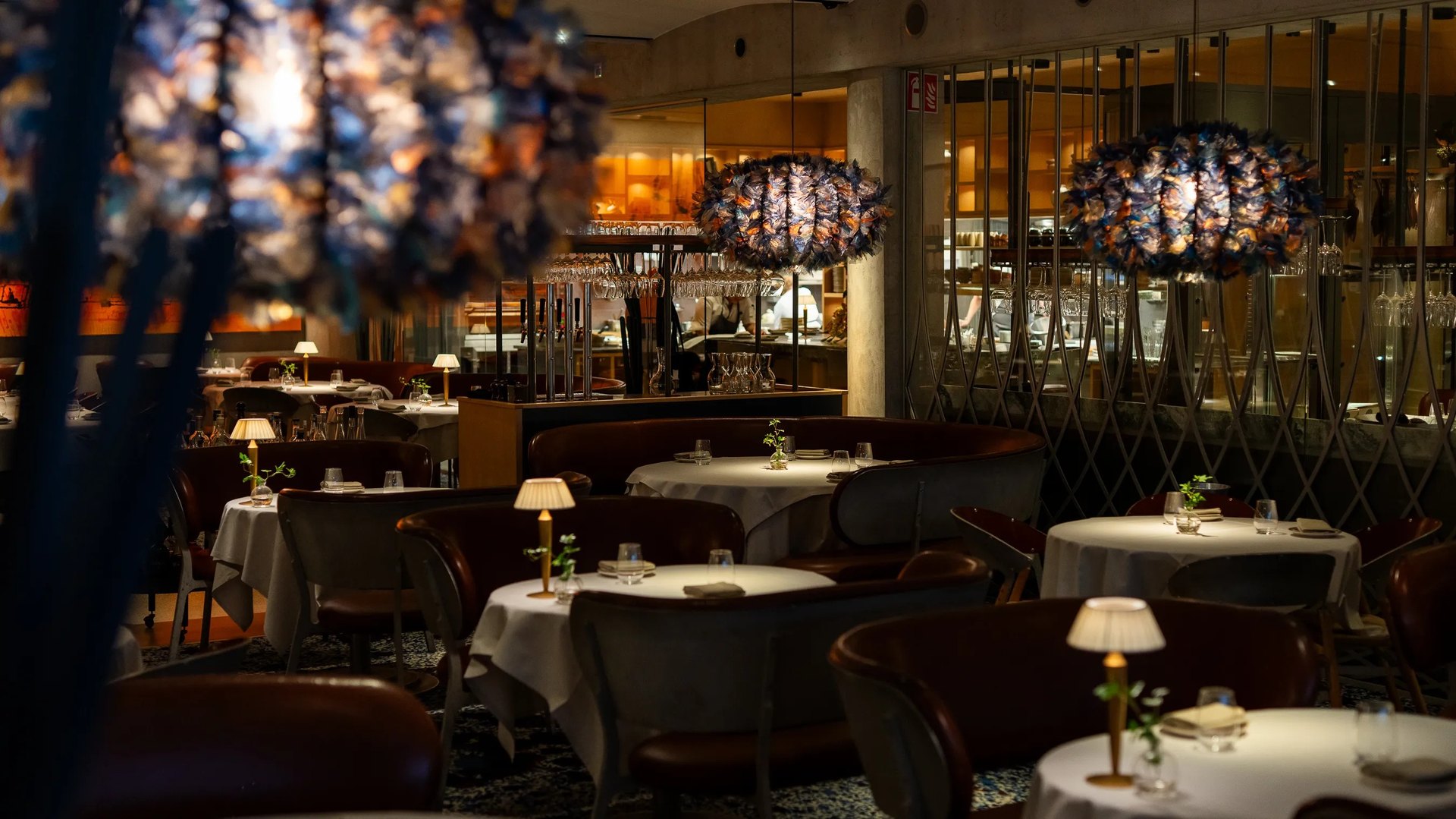 Hillenberg’s dining room of white-clothed tables and leather chairs under sculptural lamps
