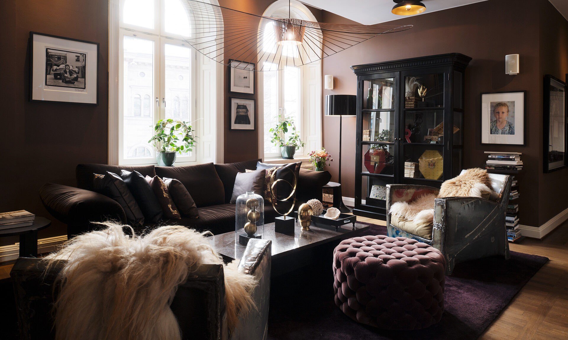 A lounge at Lydmar Hotel, with sheepskins, velvet and photographs on dark walls